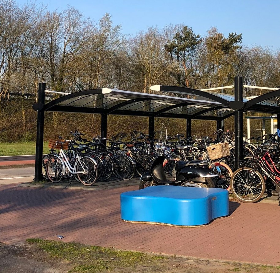 Hub Westlaren, met een zitelement en een overdekte fietsenstalling.