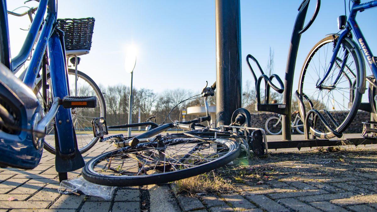 Een kapotte fiets ligt op de grond op een hub.