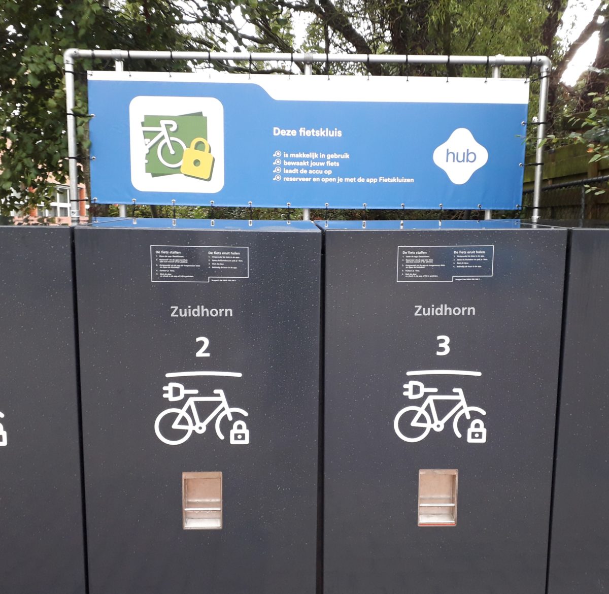 Fietskluizen op de hub in Zuidhorn. Boven de kluizen staat een uitleg hoe je een fietskluis kunt gebruiken.