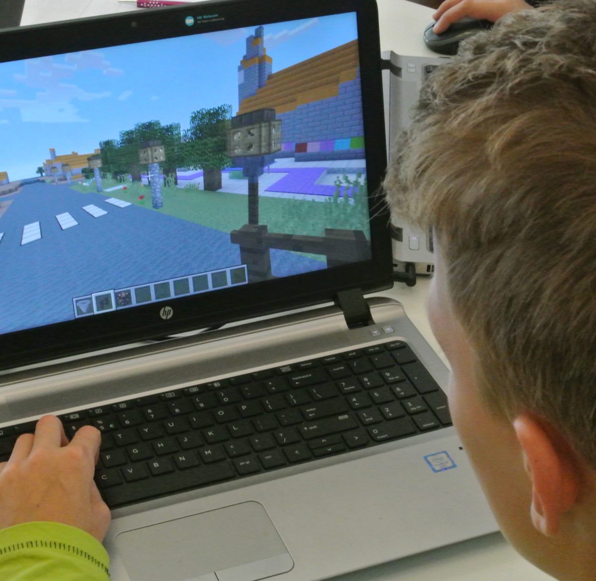 Een jongen speelt het spel Minecraft op een laptop.