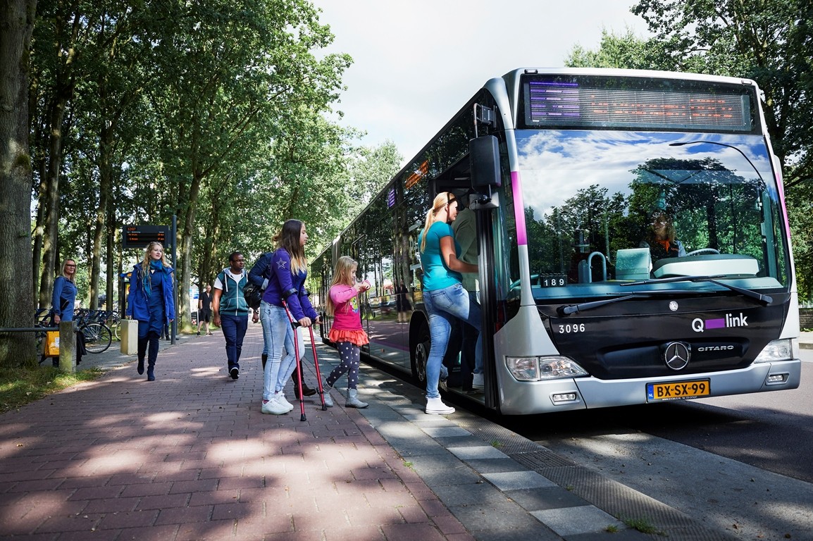 Verschillende reizigers stappen in de bus op een hub