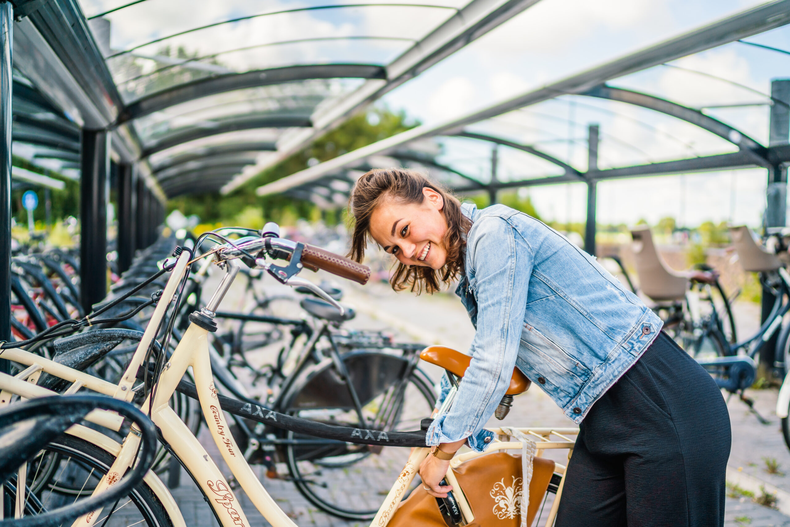 Een vrouw parkeert haar fiets in een overdekte fietsenstalling op een hub.